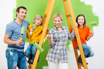 Happy family painting wall in green.